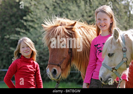 Due giovani ragazze con i loro pony Foto Stock