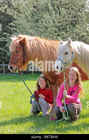 Due giovani ragazze con i loro pony Foto Stock