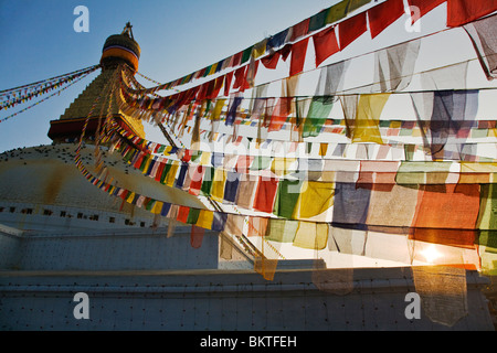 Preghiera tibetano bandiere soffiare la brezza a sunrise - BODHANATH STUPA, Kathmandu, Nepal Foto Stock