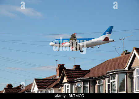 Un bmi British Midland Airbus A319-131 atterraggio all' Aeroporto di Heathrow di Londra, Regno Unito. Vista dal Mirto Avenue, Hounslow. (G-DBCF) Foto Stock