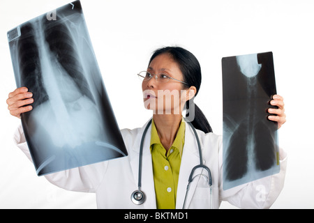 Asian medico donna recensioni dei risultati di una radiografia del torace. Inquadratura orizzontale. Isolato su bianco. Foto Stock