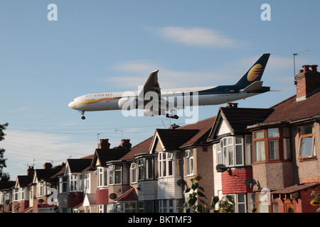 Un Jet Airways Boeing 777-35R/ER atterraggio all' Aeroporto di Heathrow di Londra, Regno Unito. Vista dal Mirto Avenue, Hounslow. (VT-JEA) Foto Stock