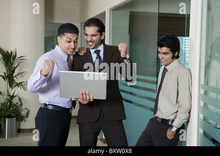 Imprenditori guardando il computer portatile in ufficio Foto Stock