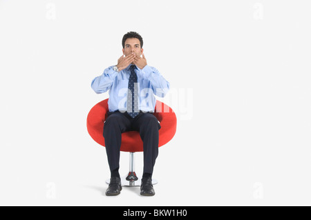 Giovane imprenditore che copre la bocca, ritratto Foto Stock