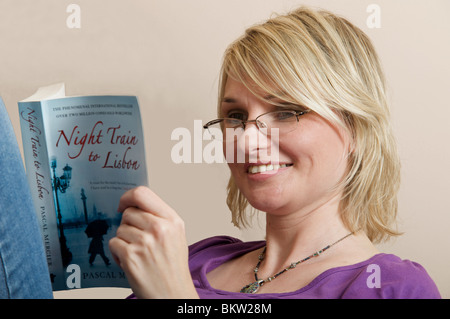 La donna la lettura del best seller internazionale treno notte a Lisbona da Pascal Mercier Foto Stock