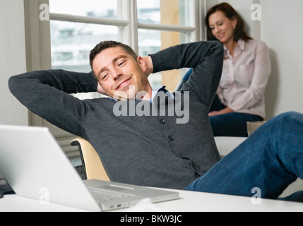 Uomo con le mani dietro la testa Foto Stock