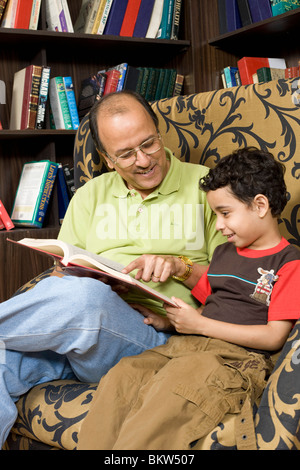 Il nonno con il nipote la lettura di un libro delle fiabe Foto Stock