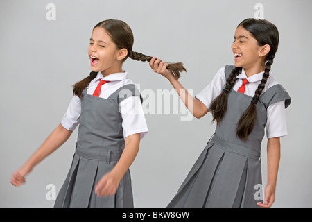 Uno naughty School girl tirando un altro ragazze capelli Foto Stock