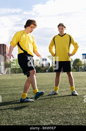 Due amici che giocano a calcio Foto Stock