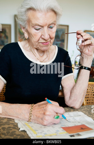 Signora risolvere cruciverba Foto Stock