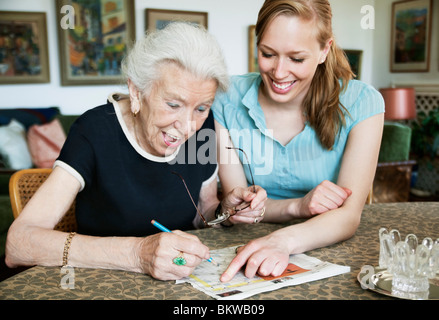 Felici donne risoluzione cruciverba Foto Stock