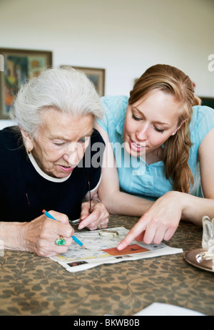 Due persone risolvere cruciverba Foto Stock
