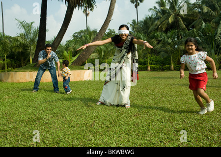 Famiglia giocando "cieco mans bluff' nel loro giardino Foto Stock