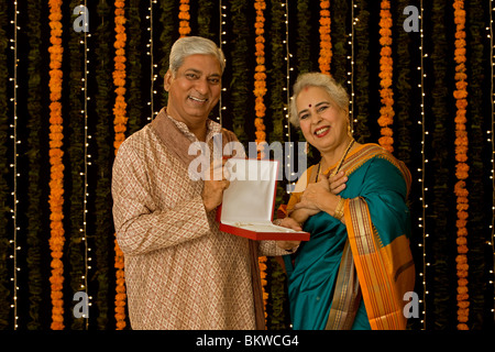 Uomo indiano dando una gioielleria a sua moglie Foto Stock