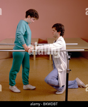 Maschio terapista fisico per la riabilitazione di una donna vittima di incidente. Foto Stock