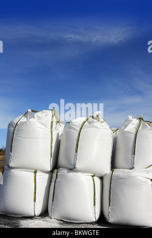 Sale sacchi bianco righe impilate per evitare strade di ghiaccio asfalto Foto Stock