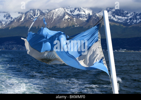 Bandiera argentina con la città di Ushuaia e le montagne delle Ande in background Foto Stock