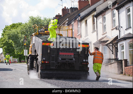 Rifacimento della pavimentazione stradale mediante un trattamento di conservazione medicazione di superficie di emulsione di bitume e trucioli di pietra Newport South Wales UK Foto Stock