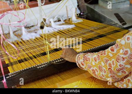 Songket tradizionale tessitura nel Terengganu, Malaysia. Songket è una raffinata seta intrecciati con filo d'oro. Foto Stock