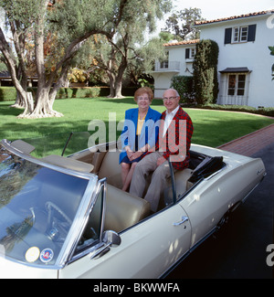 Ritratto di coppia in pensione e antichi convertible Chevrolet auto al di fuori del loro Southern California home Foto Stock