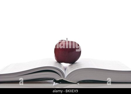 Libro aperto e mela rossa Foto Stock