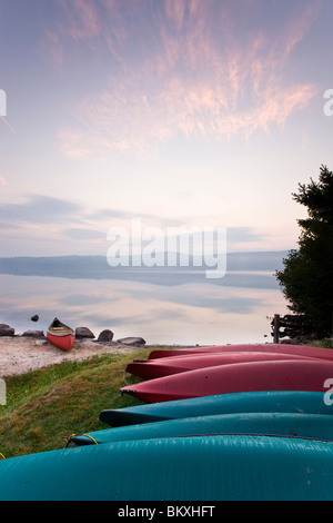 Canoe e kayak sul litorale del Lago Sunapee presso sunrise a Mount Sunapee parco dello stato a Newbury, New Hampshire. Foto Stock