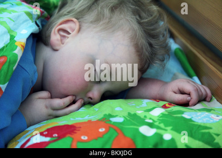 BAMBINO DI DUE ANNI STANCO DI DORMIRE CON LE GUANCE ROSATE: Un bambino di due anni bambino bambino bambino bambino addormentato nel modello pomeridiano rilasciato Foto Stock