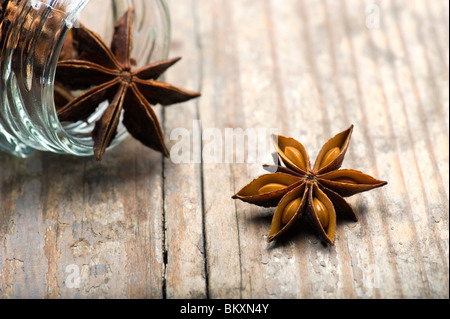 Anice stellato (Illicium verum) la fuoriuscita del vaso su una tavola di legno Tavolo da cucina Foto Stock