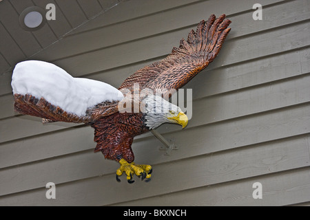 Decorazioni scolpite di eagle parzialmente coperto di neve, al di fuori di casa in aderenza porto sulle rive del lago Tahoe, South Lake Tahoe, Ne Foto Stock