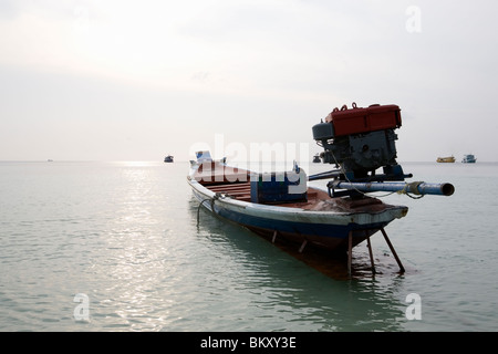 Barca dalla coda lunga nei fondali bassi durante il tramonto a Koh Tao, Thailandia Foto Stock