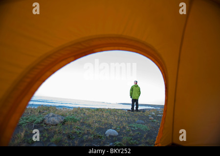 Un uomo è visto attraverso una tenda sulla costa perso, California. Foto Stock