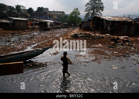 Ristagno di acqua sul fiume Kroo Bay bidonville, Freetown, Sierra Leone Foto Stock
