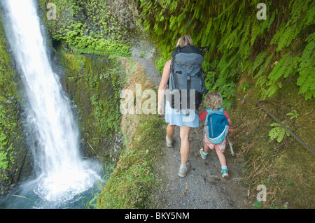 Una donna e di sua figlia escursionismo passato una cascata, Eagle creek, Oregon. Foto Stock