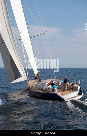 Un equipaggio gare un moderno oceaniche yacht a vela. Foto Stock