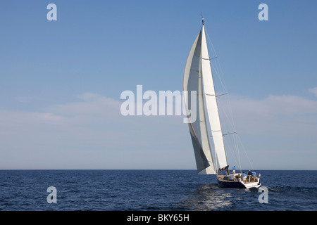Un equipaggio gare un moderno oceaniche yacht a vela. Foto Stock
