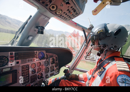 A nord-ovest di aria pilota ambulanza vola mountain rescue ai membri del team di un incidente sul sito di Langdale Pikes, Lake District, UK. Foto Stock