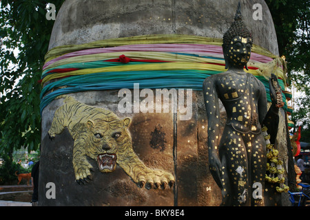 Statua di Buddha nella parte anteriore di una campana al Wat Phra Bang, un tempio buddista in Thailandia dove i monaci devoti del tatuaggio. Foto Stock