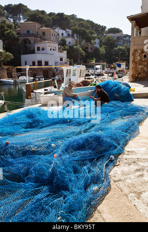Due pescatori a riparare le reti da pesca al porto di Cala Figuera Maiorca Isole Baleari, Mare mediterraneo, Spagna, Foto Stock
