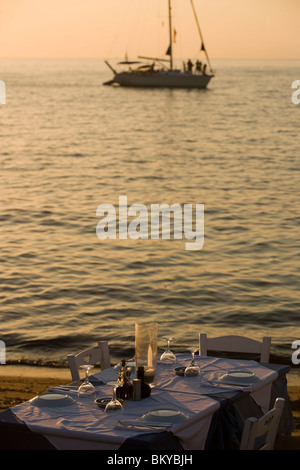 Vista su una tabella con i bicchieri e piatti in un sailingboat sul mare, Little Venice, Mykonos-Town, Mykonos, Grecia Foto Stock