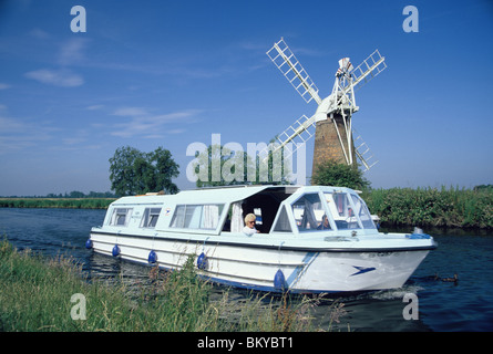 Barche da diporto sul canale accanto a come Hill windpump, Norfolk Broads, Inghilterra Foto Stock