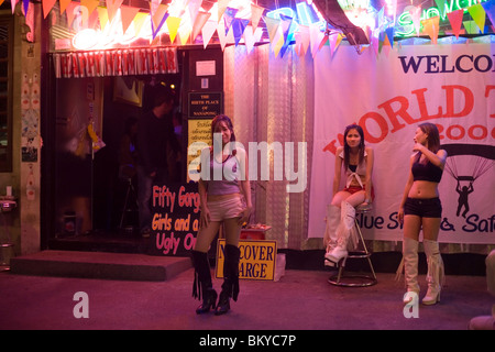 Tre go-go le ragazze nella parte anteriore di un nightclub, Patpong, la luce rossa e il quartiere dei divertimenti, Bang Rak distretto, Bangkok, Thailandia Foto Stock