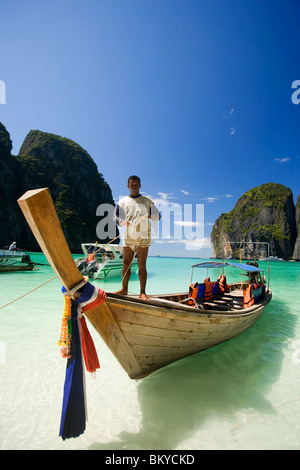 Boatman in piedi su di una barca dalla coda lunga e tenendo una corda, Maya Bay, una bellissima SCENIC LAGUNA, famoso per il film di Hollywood " Foto Stock