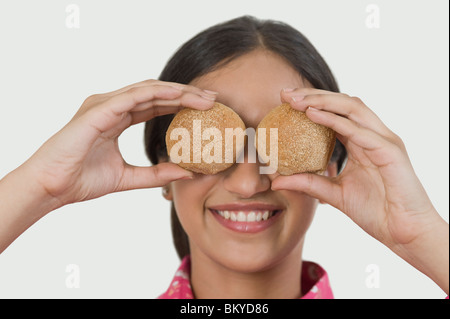 Donna che mantiene due tipi di pane davanti agli occhi Foto Stock