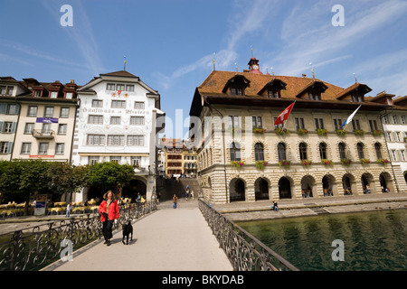 La donna con il cane a piedi oltre il ponte Rathaussteg, al municipio di Rathausquai in background, Fiume Reuss, Lucerna, Canton Lucerna, Sw Foto Stock