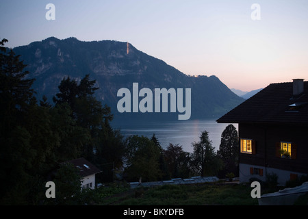 Vista lungo una casa illuminata sul Lago di Lucerna in serata, Weggis, il cantone di Lucerna, Svizzera Foto Stock