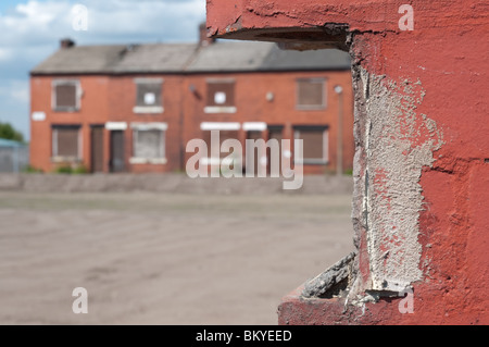 Fila di intavolato case a schiera in attesa di demolizione.East Manchester,Inghilterra.parzialmente demolito proprietà in primo piano. Foto Stock