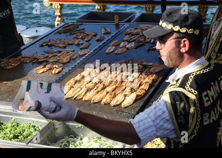 Il famoso barche vendita di pesce alla griglia panini, conosciuto localmente come Balik Ekmek a Eminonu harbourside ad Istanbul in Turchia Foto Stock