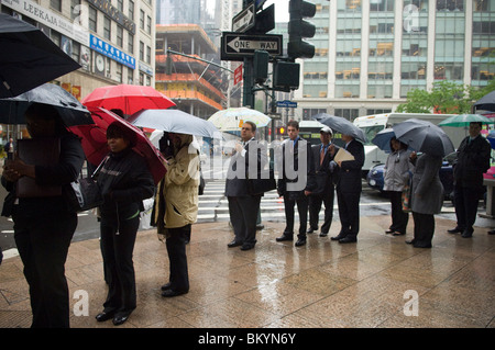 Le persone in cerca di lavoro linea fino ad un processo equo, sotto la pioggia, in Midtown a New York il Mercoledì, 12 maggio 2010. ( © Francesca M. Roberts). Foto Stock