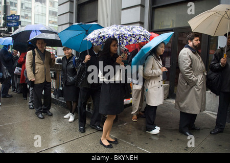 Le persone in cerca di lavoro linea fino ad un processo equo, sotto la pioggia, in Midtown a New York il Mercoledì, 12 maggio 2010. ( © Francesca M. Roberts). Foto Stock