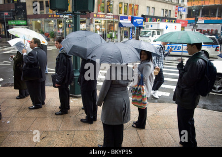 Le persone in cerca di lavoro linea fino ad un processo equo, sotto la pioggia, in Midtown a New York il Mercoledì, 12 maggio 2010. ( © Francesca M. Roberts). Foto Stock